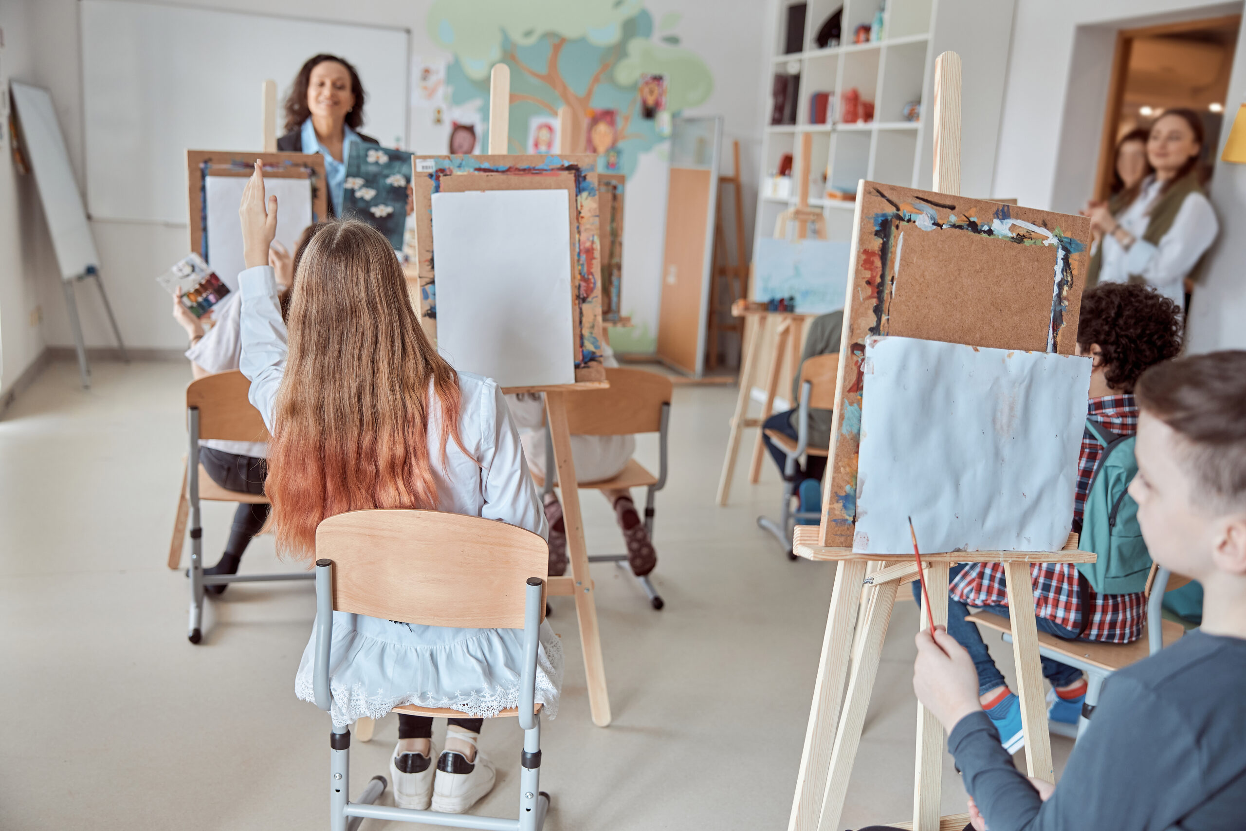 Adults painting at easels in an art class