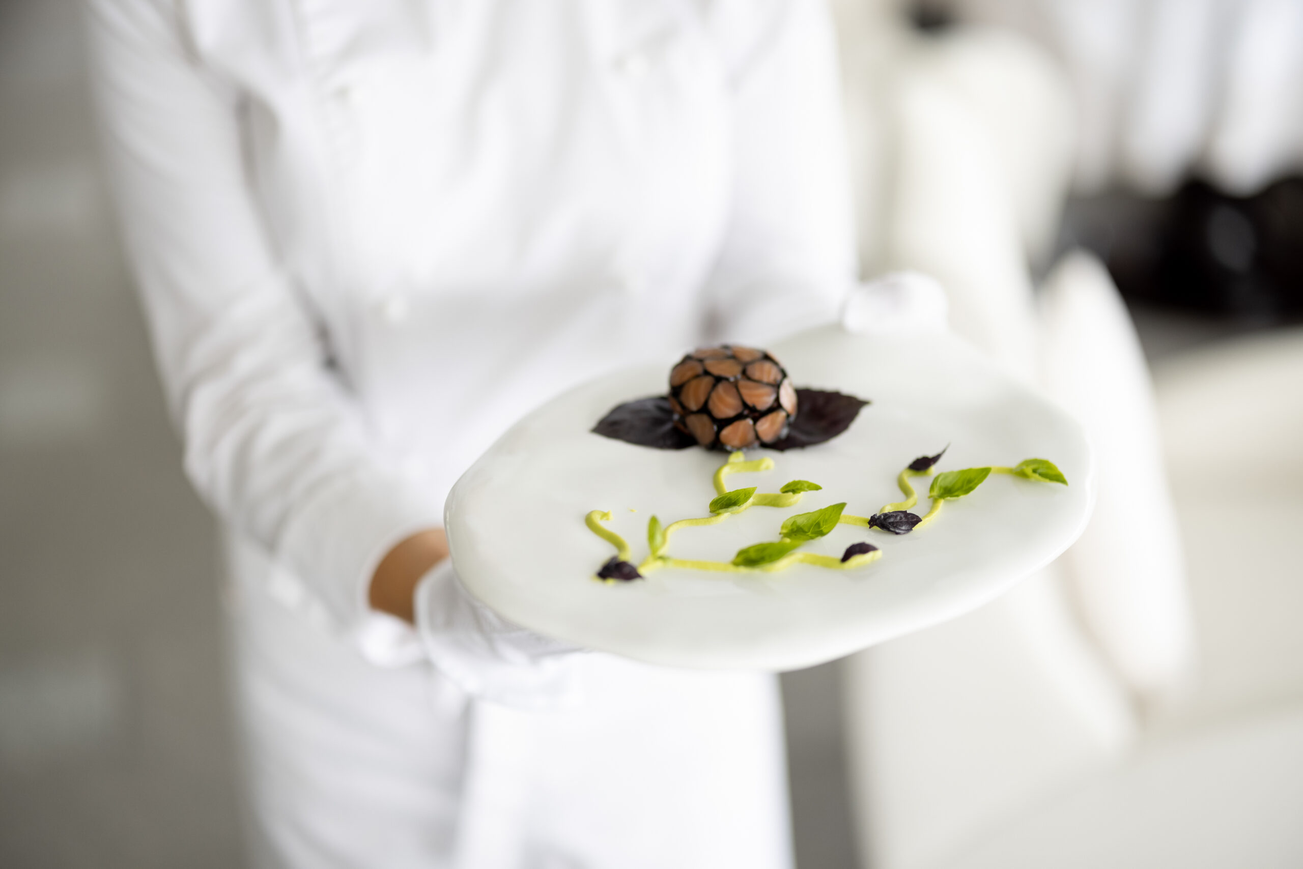 Chef presenting a plated dish at a fine dining restaurant